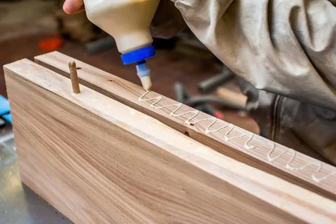 Gluing boards in a carpentry workshop. Connecting with dowels and glue. Manuf Stock Photos