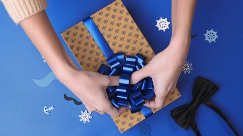Gluing the bow to the present box for men, wrapping the present, parcel Stock Footage 102033169