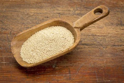 Gluten free amaranth grain on a rustic wooden scoop against grunge wood table Stock Photos