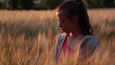 Gluten Free girl in barley field shredding barley head and throwing it away. Stock Footage