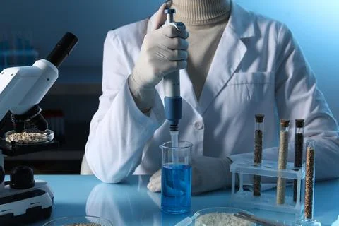 GMO concept. Scientist dripping sample into beaker at table with test tubes.. Foto stock