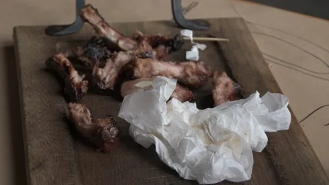 Gnawed fried ribs with meat are lying on a wooden cutting board. Leftovers from  스톡 동영상 157229992