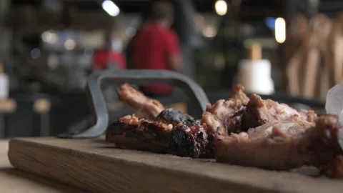 Gnawed fried ribs with meat are lying on a wooden cutting board. Leftovers from  Video stock 157230044