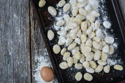 Gnocchi on cookie sheet and rustic wooden background Stock Photos