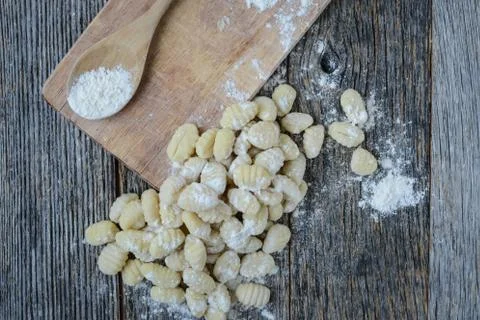 Gnocchi on cutting board and rustic wood background Stock Photos