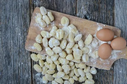 Gnocchi on cutting board and rustic wood background Stock Photos