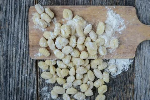 Gnocchi on cutting board and rustic wood background Stock Photos