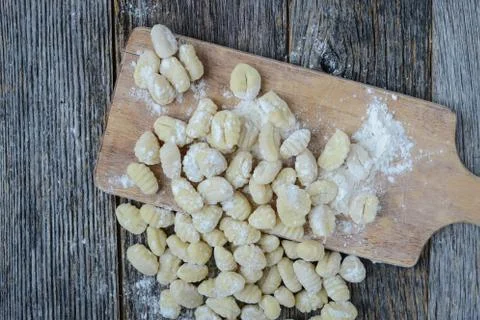 Gnocchi on cutting board and rustic wood background Stock Photos