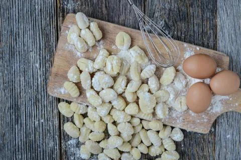Gnocchi on cutting board and rustic wood background Stock Photos