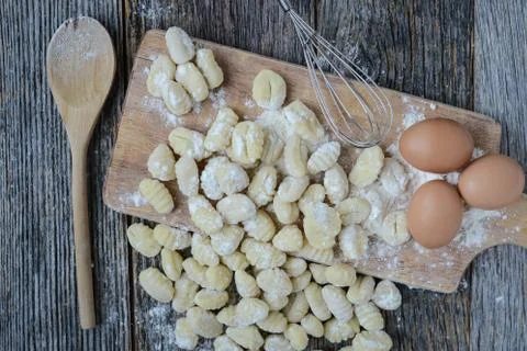 Gnocchi on cutting board and rustic wood background Stock Photos