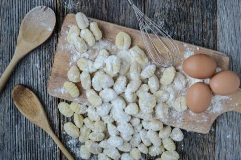 Gnocchi on cutting board and rustic wood background Stock Photos
