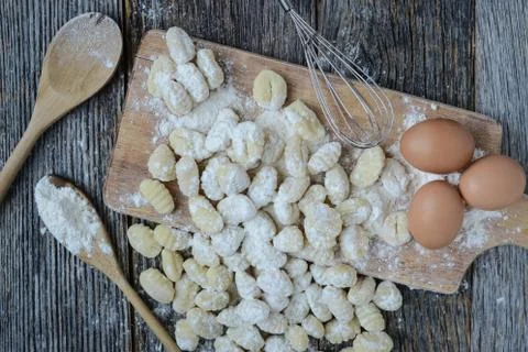 Gnocchi on cutting board and rustic wood background Stock Photos