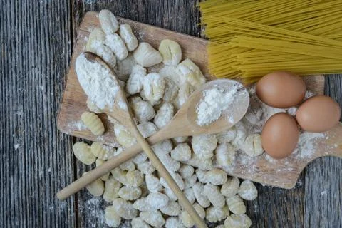 Gnocchi on cutting board and rustic wood background Stock Photos
