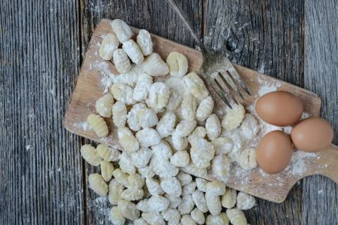 Gnocchi on cutting board and rustic wood background Stock Photos