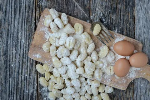 Gnocchi on cutting board and rustic wood background Stock Photos