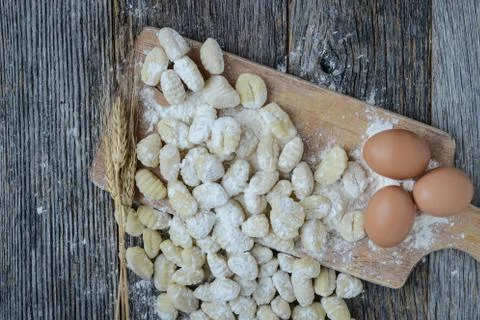 Gnocchi on cutting board and rustic wood background Stock Photos