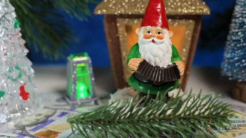 A gnome and a Christmas tree branch against of fir trees and a Christmas lantern Stock Footage 336971030