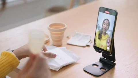 Go green zero waste reusable period cup live stream selfie talk on phone Stockbeeldmateriaal 289706751