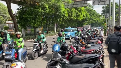 GO-JEK drivers, wait outside the Palmerah railway station in Jakarta Vídeo Stock 301080848