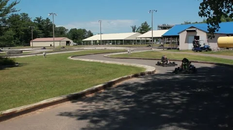 Go Karts go through shaded track Stock Footage 64530642