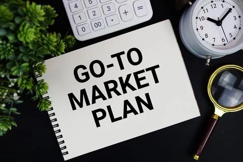Go-To-Market Plan text written on notepad with alarm clock, magnifying glas.. Stock Photos