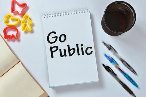 Go public text on notepad with office accessories. Business motivation, inspi Stock Photos