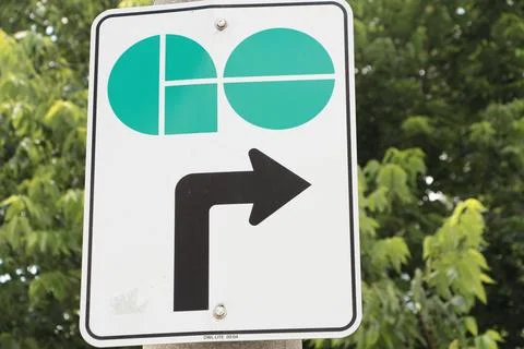 Go train vertical rectangle sign logo with arrow pointing up and right with tree Stock Photos