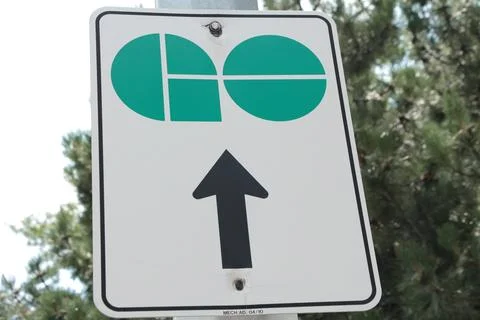 Go train vertical rectangle sign logo with arrow pointing up with trees behind Stock Photos