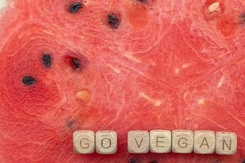 Go vegan message on watermelon background with wooden tiles promoting plant-b Stock Photos