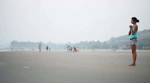 GOA, INDIA - CIRCA 2013: Praying Indian girl on the beach. Sunset Stock Footage 43041331