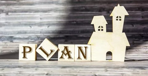 Goal, plan, action text on blocks on a wooden table with a house concept. Bus Stock Photos