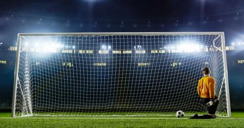 Goalkeeper is trying to save from a goal on an empty soccer stad Stock Photos