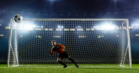 Goalkeeper is trying to save from a goal on an empty soccer stad Stock Photos