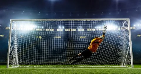 Goalkeeper is trying to save from a goal on an empty soccer stad Stock Photos