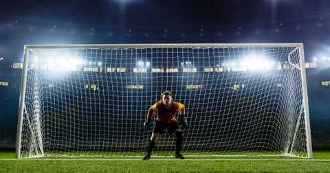 Goalkeeper is trying to save from a goal on an empty soccer stad Stock Photos