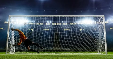 Goalkeeper is trying to save from a goal on an empty soccer stad Stock Photos