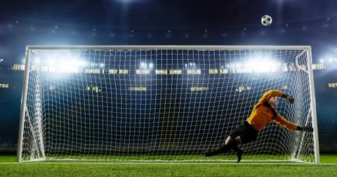 Goalkeeper is trying to save from a goal on an empty soccer stad Stock Photos