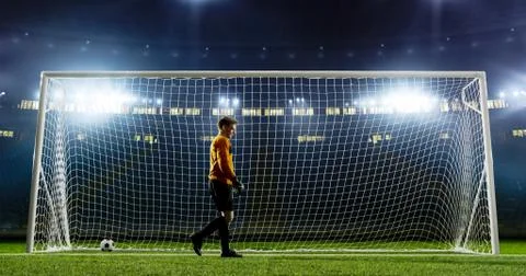 Goalkeeper is trying to save from a goal on an empty soccer stad Stock Photos