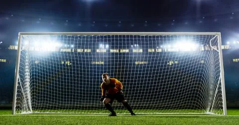 Goalkeeper is trying to save from a goal on an empty soccer stad Stock Photos