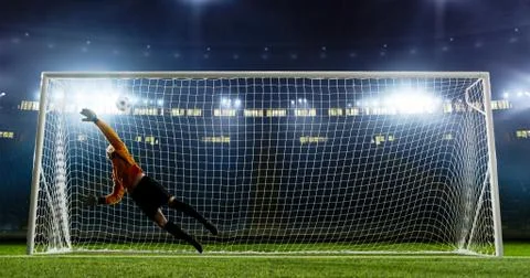 Goalkeeper is trying to save from a goal on an empty soccer stad Stock Photos