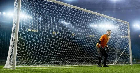 Goalkeeper is trying to save from a goal on an empty soccer stad Stock Photos