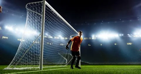 Goalkeeper is trying to save from a goal on an empty soccer stad Stock-Fotos