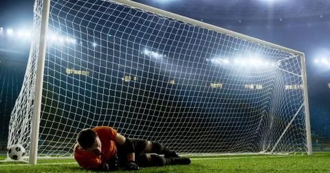 Goalkeeper is trying to save from a goal on an empty soccer stad Stock Photos