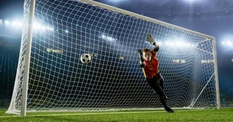Goalkeeper is trying to save from a goal on an empty soccer stad Stock Photos