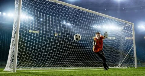 Goalkeeper is trying to save from a goal on an empty soccer stad Foto stock