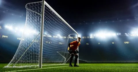 Goalkeeper is trying to save from a goal on an empty soccer stad Stock Photos