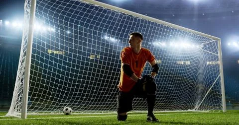 Goalkeeper is trying to save from a goal on an empty soccer stad Stock Photos