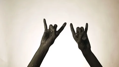 Goat gesture on a dark background. Black hand doing rock symbol. Hands up at  Stock Footage 100681392