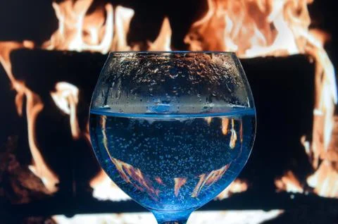 Goblet with bubbles on the background of the fireplace Stock Photos
