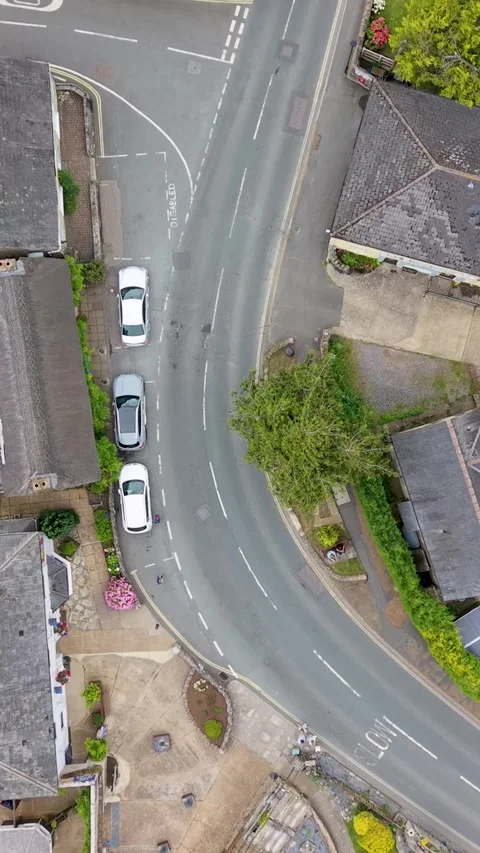 Godshill road bend as bus and cars navigate village curve, vertical ascending Stockbeeldmateriaal 339045375